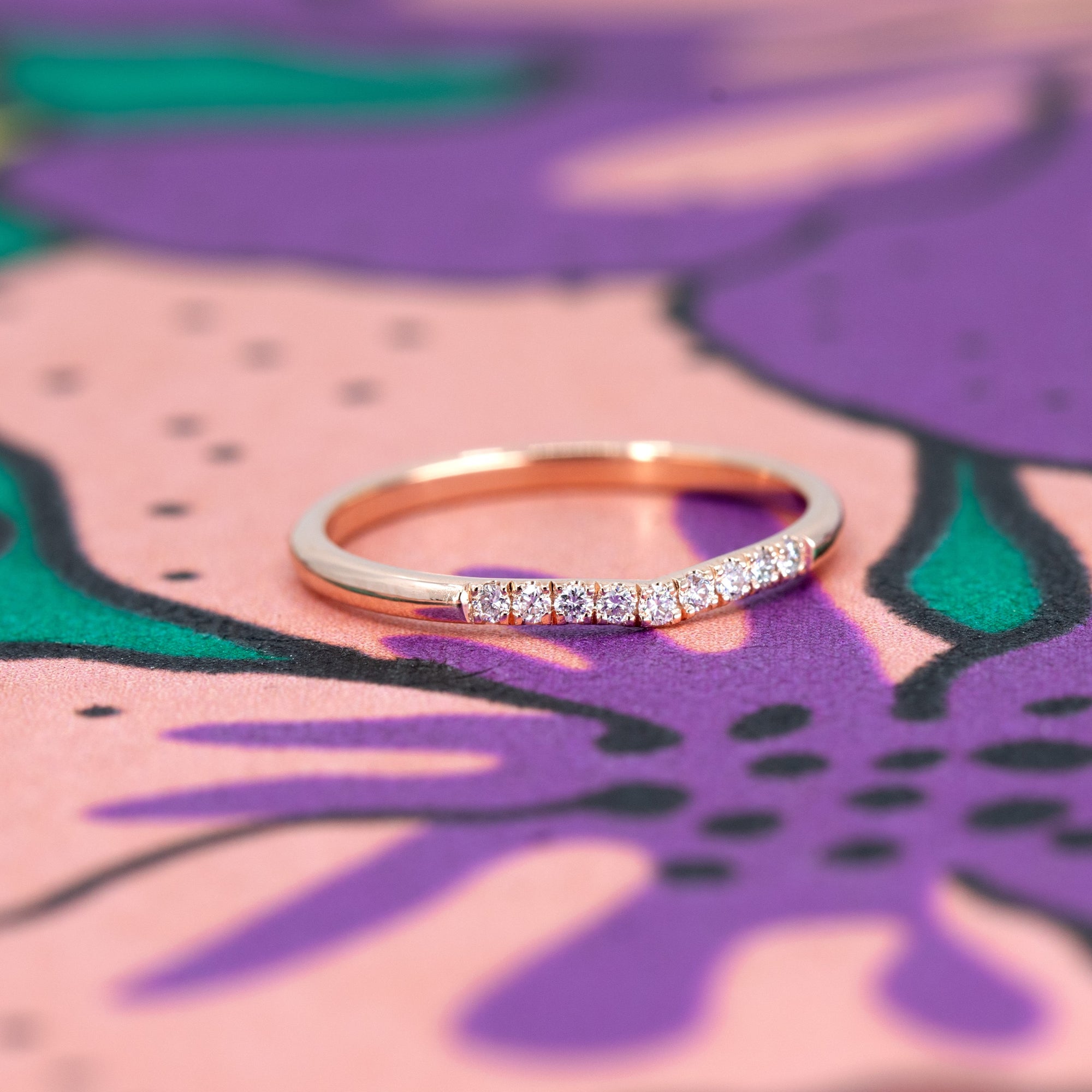 Luna Band – A delicate rose gold curved diamond ring displayed on a soft-toned background. Handmade by Bena Jewelry, an independent jewelry designer from Montreal.
