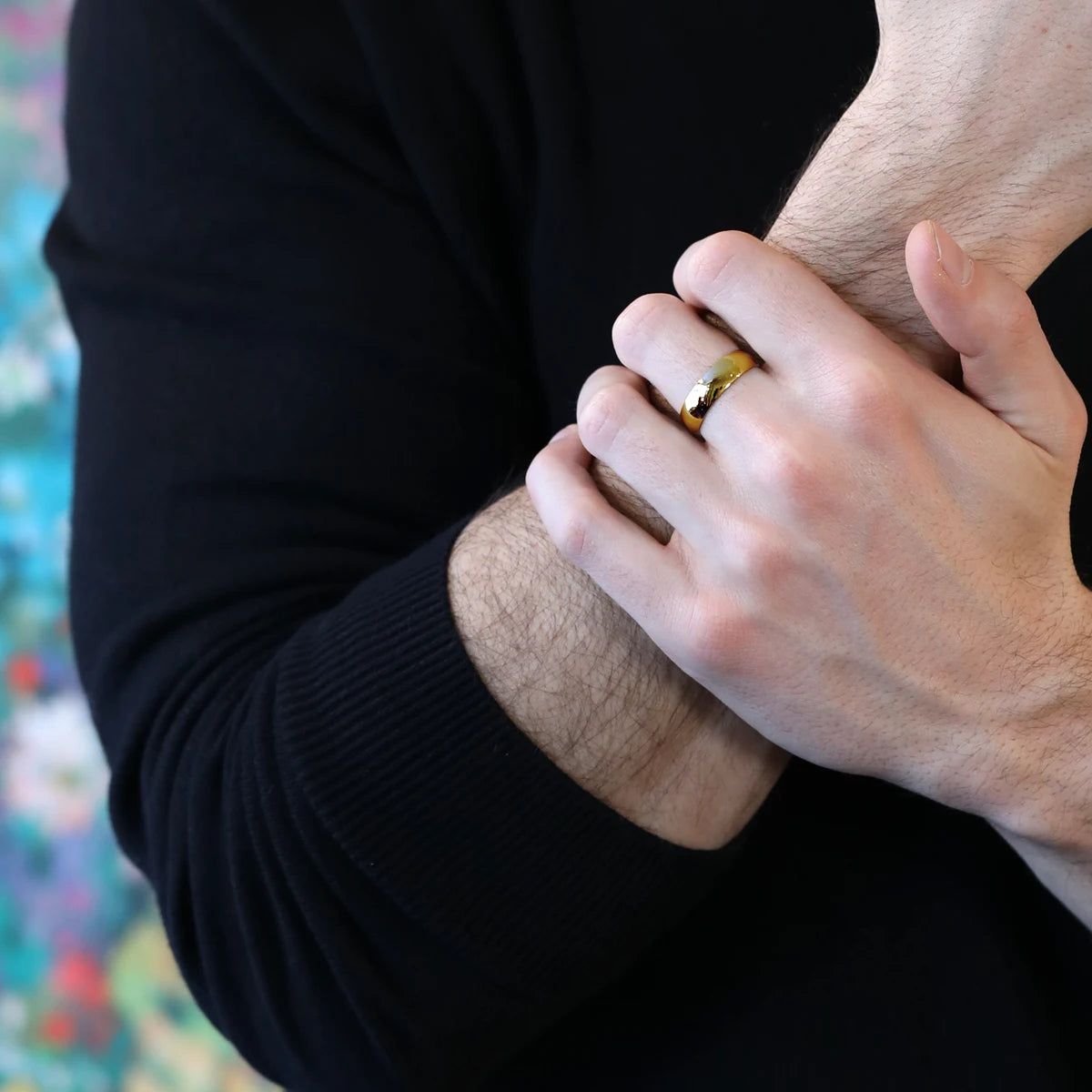 Men wearing a sleek yellow gold wedding ring with a polished dome design, custom-made by Bena Jewelry in Montreal, Canada for a refined and classic style.