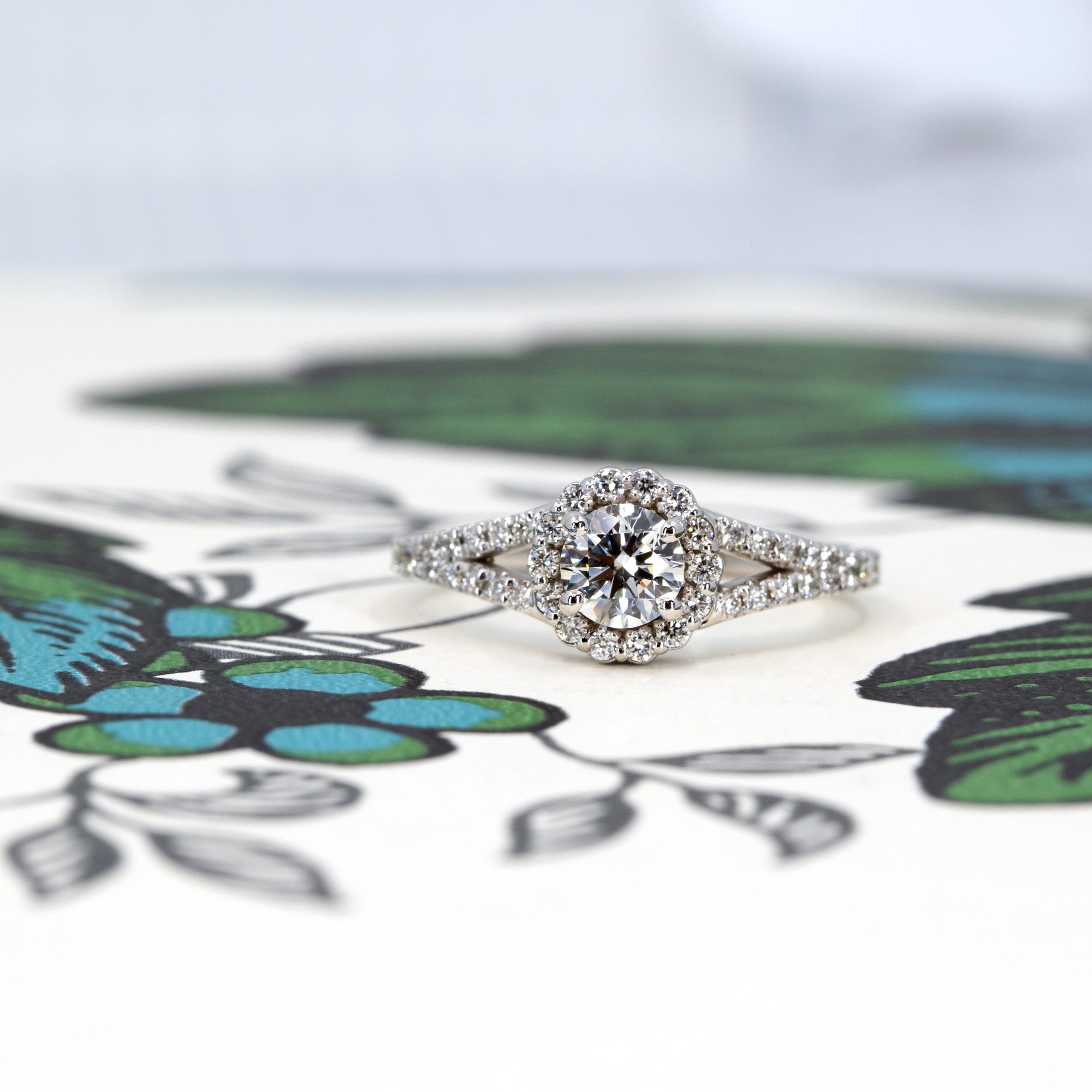 Lab-grown diamond halo engagement ring in white gold, photographed on a colored background. Showcasing timeless bridal elegance by Bena Jewelry, made in Montreal.