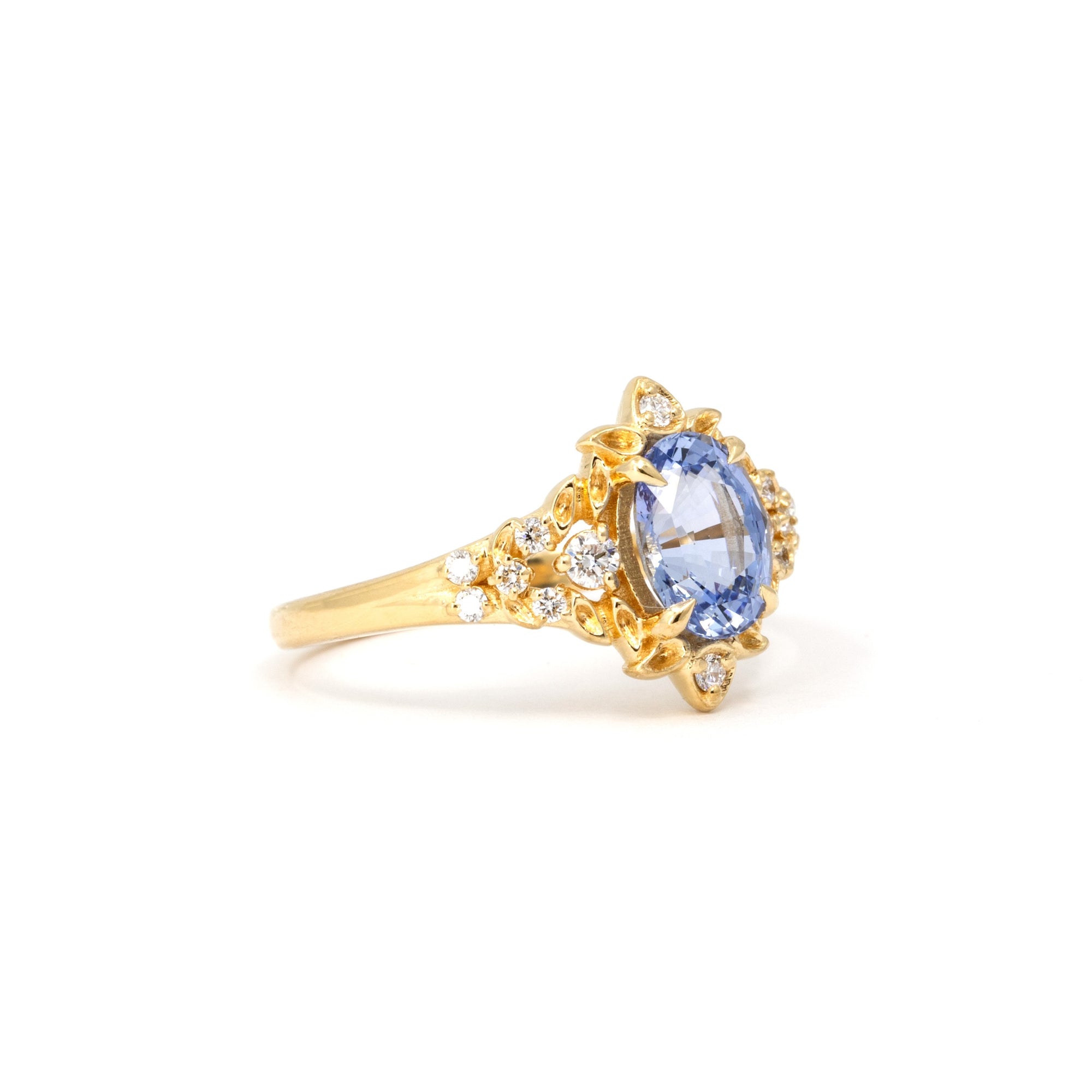 Close-up of Sky Bloom Ring – A natural oval sapphire with soft blue hues, set in a delicate yet intricate organic gold setting.