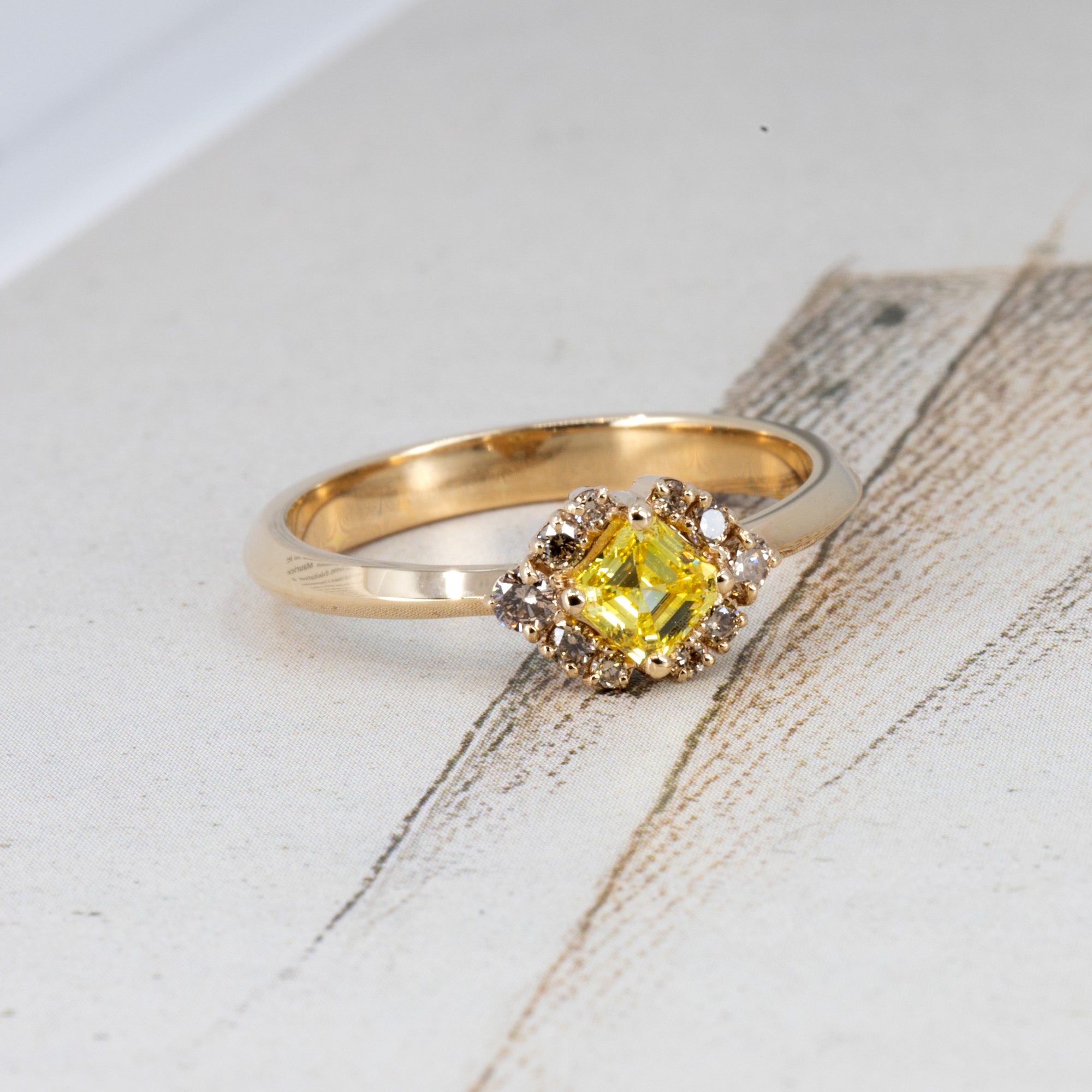 Yellow Asscher-cut diamond ring by Bena Jewelry pops against a vibrant colored background, showcasing its unique contrast and handcrafted 14k gold setting, made in Montreal.