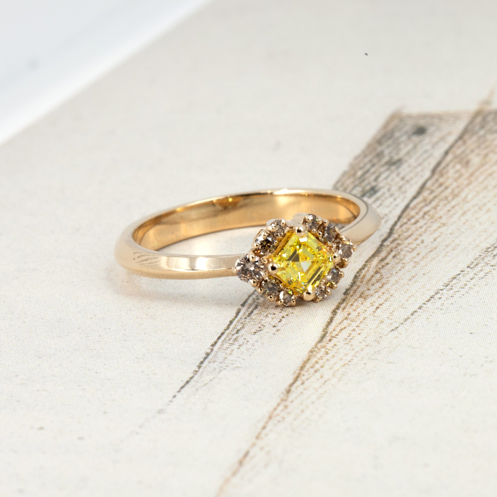 Artistic composition of a one-of-a-kind yellow and brown diamond ring by Canadian designer Bena Jewelry, photographed on a soft-toned backdrop for a modern look.