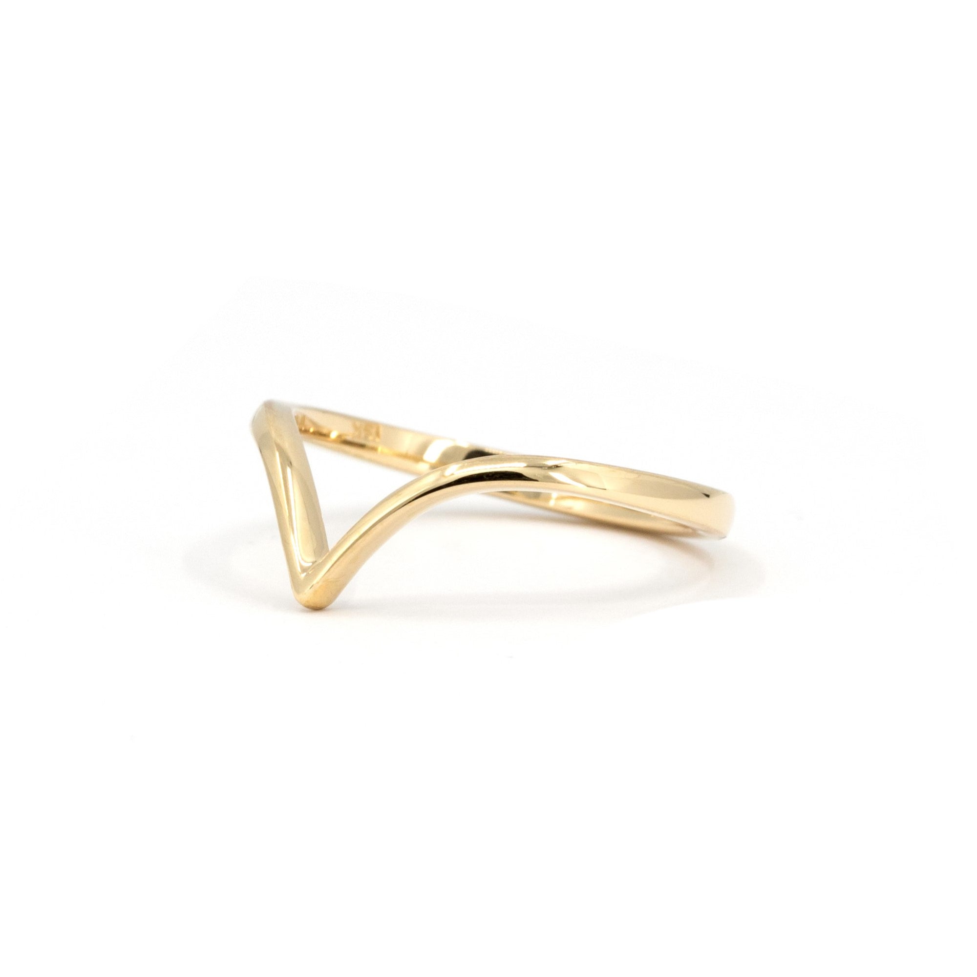 Bridal wedding band with a soft V contour, photographed in white lighting – A modern yet classic gold wedding ring, made in Canada.