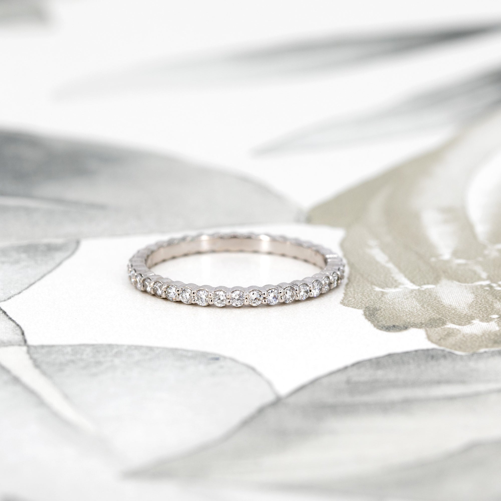 Close-up view of the 1.50 mm round diamonds on the white gold eternity band by Bena Jewelry. A perfect blend of sparkle and precision, highlighting its expert craftsmanship.