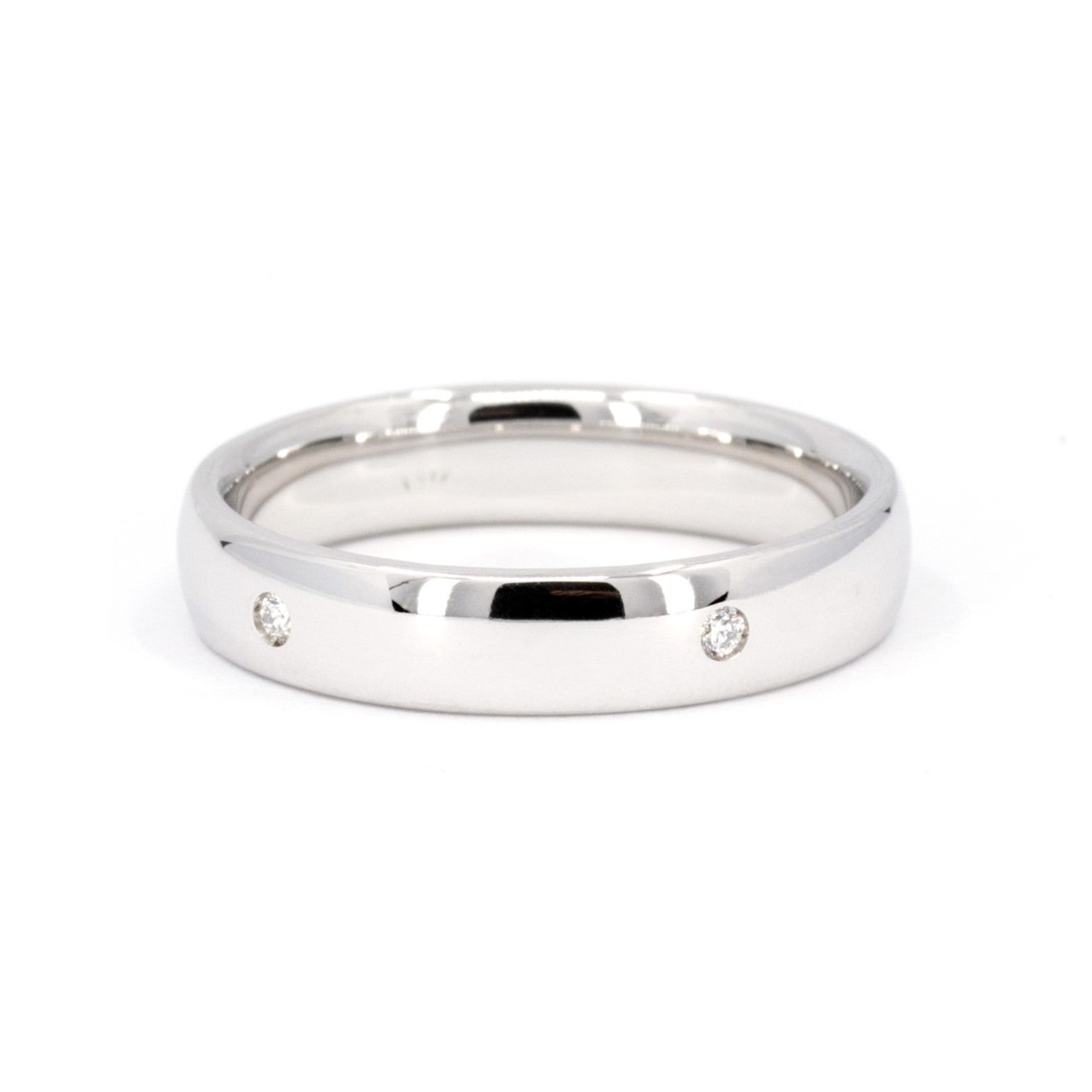 White gold wedding band with bezel-set diamonds by Bena Jewelry photographed on a clean white background custom-made bridal ring in Montreal
