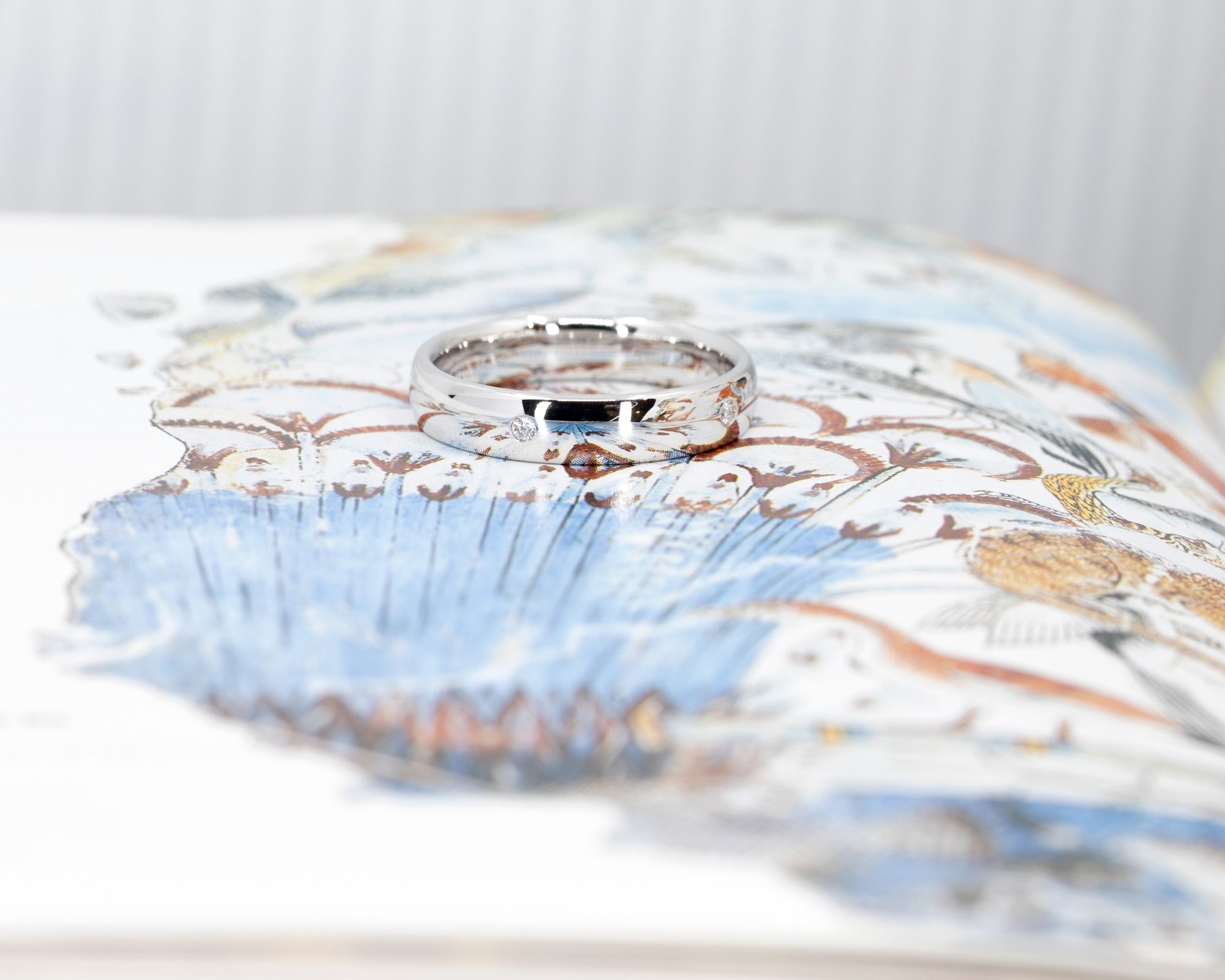 Sleek white gold wedding band with diamonds by Bena Jewelry displayed on a soft pastel background custom wedding jewelry from Montreal