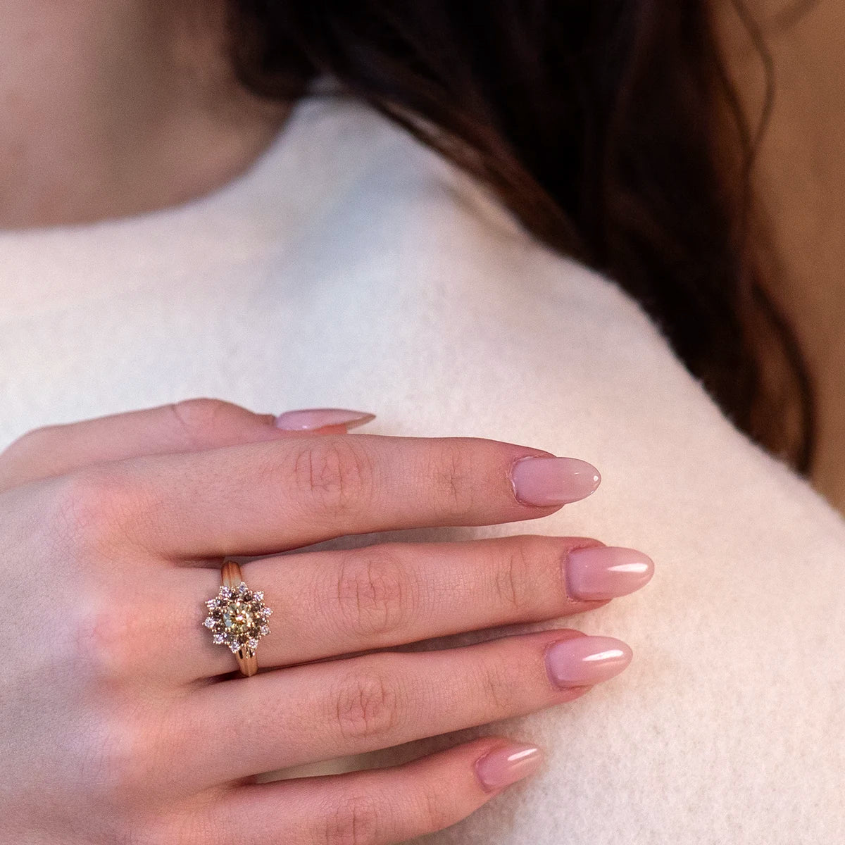 The Soleil yellow diamond ring with brown and white diamond halo, worn by a woman, showing the striking design and brilliance, crafted by Bena Jewelry.