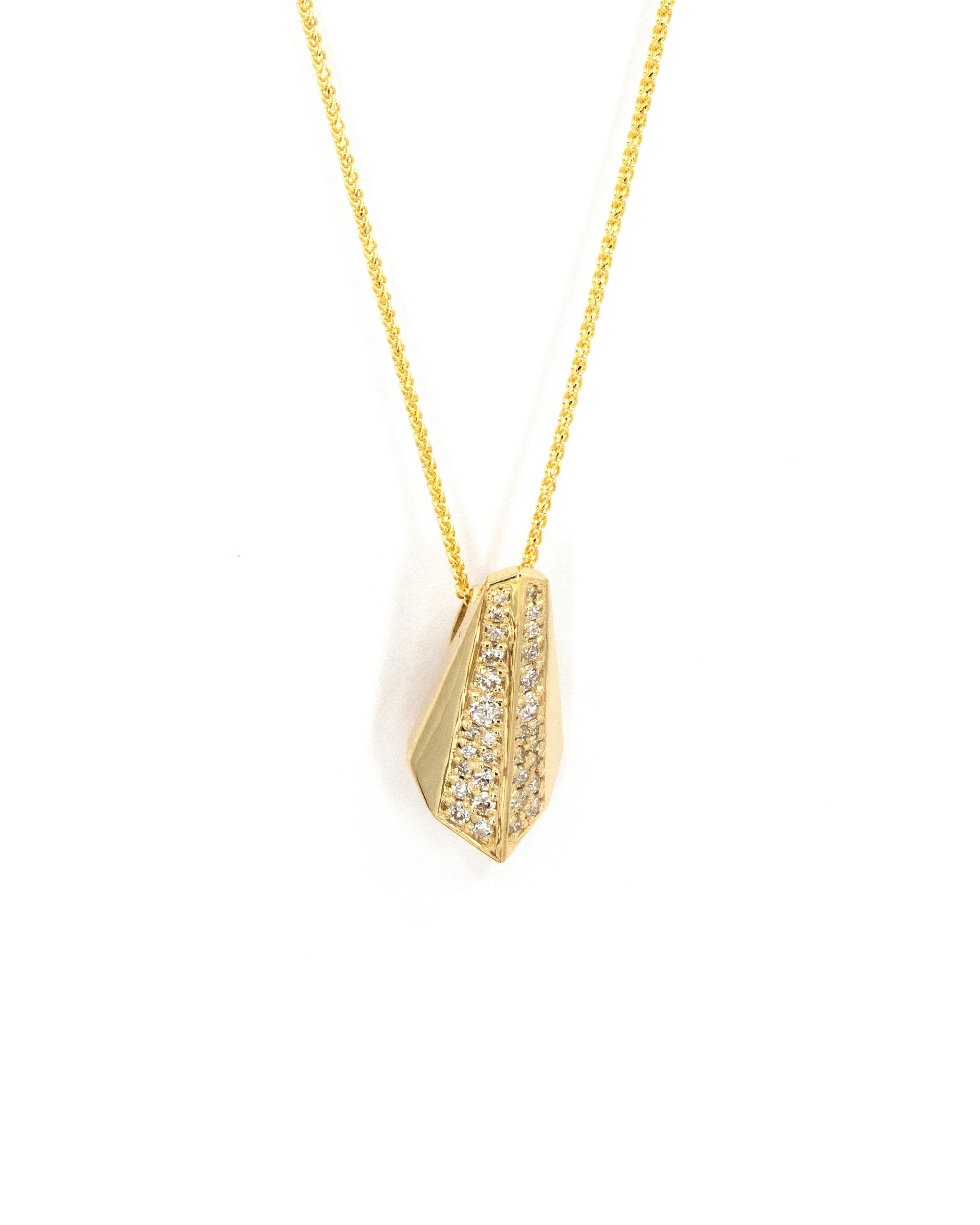 Close-up of the Ballast pendant, highlighting the dazzling diamond pavé set in yellow gold. Crafted with precision, this pendant combines bold design with sparkling brilliance.