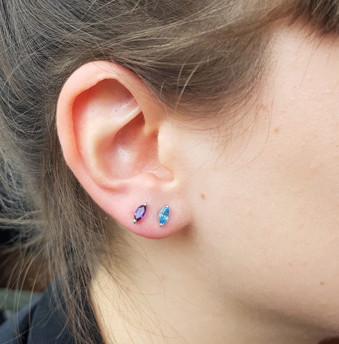 Girl wearing gemstone stud earrings marquise blue topaz