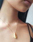 Girl wearing statement edgy vermeil gold pendant unisexe jewelry handmade in montreal bena jewelry custom made jewelry designer canada minimalist fine jewelry montreal