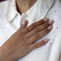 white shirt girl wearing a yellow gold ruby mardi engagement ring emeral shape brown diamond minimalist ring