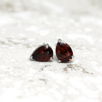 front view of pear shape garnet gemstone stud earrings red natural gemstone jewelry custom made bridal minimalist unisex fine jewelry montreal bena jewelry little italy montreal canada fine jeweler deep red garnet gemstone earrings