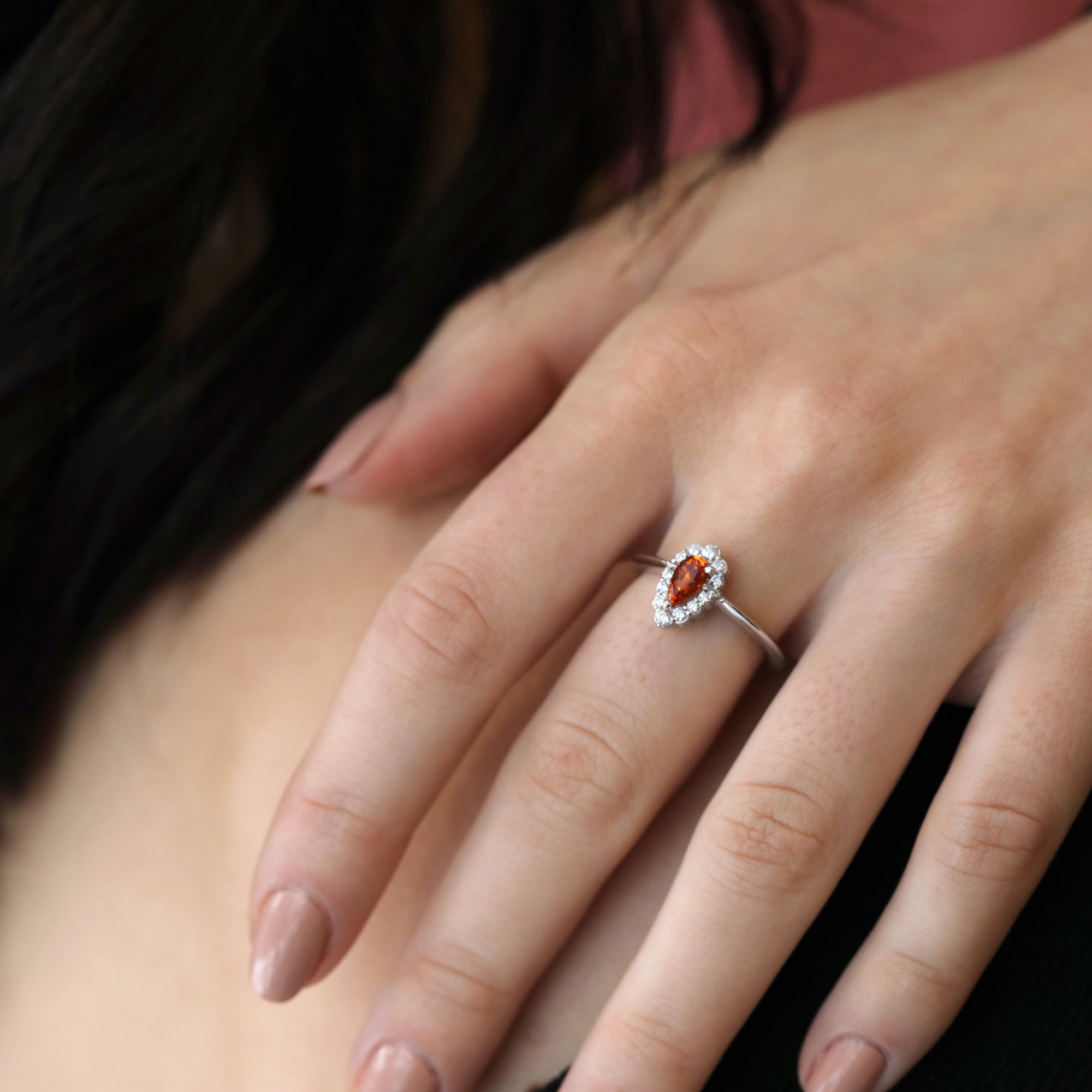 girl wearing a pear shape garnet spessartite diamond halo engagement ring bena jewelry custom color gemstone custom made engagement ring handmade in montreal little italy jewelry studio