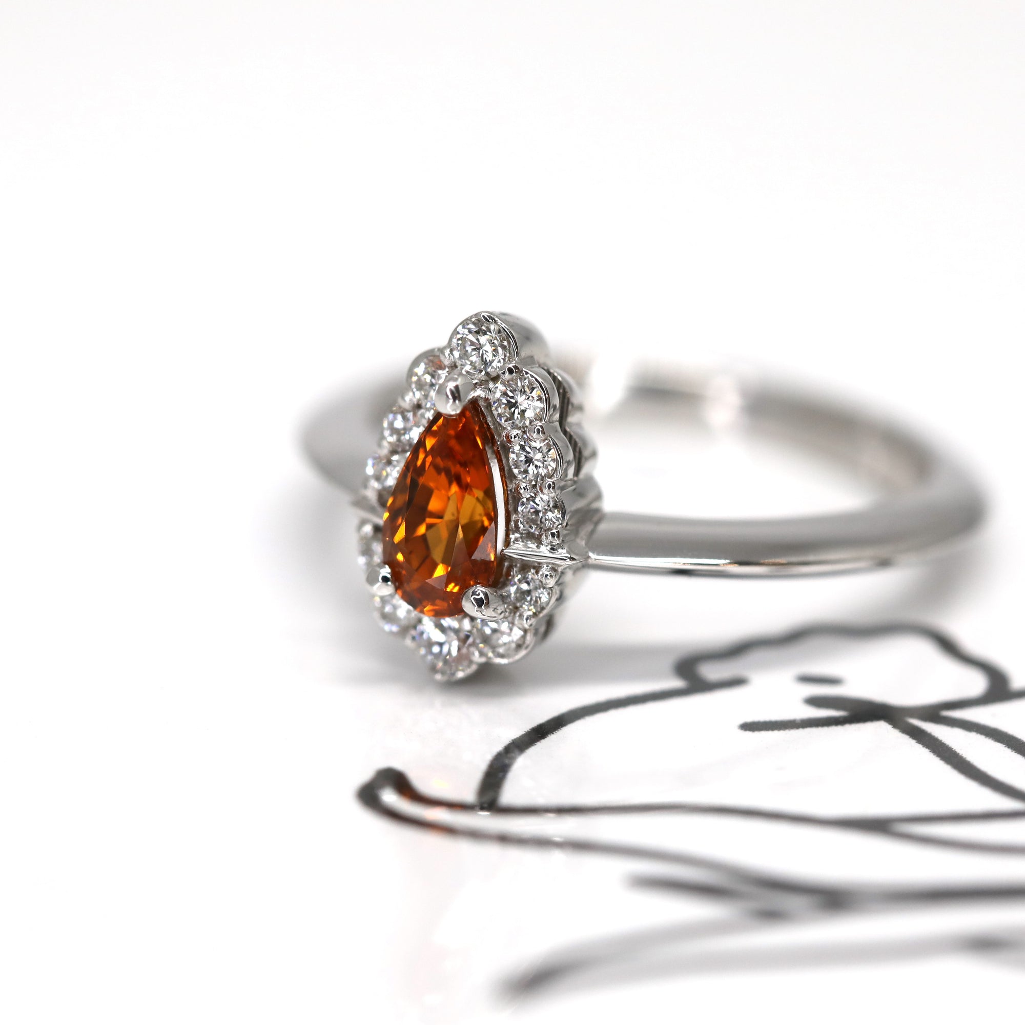 side view of pear shape orange spessartite garnet diamond ring bena jewelry custom made bridal engagement ring color gemstone bridal jewelry specialist montreal handmade in little italy jewelry studio