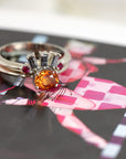 white gold garnet engagement ring made and salt and pepper ring and ruby on multicolor background