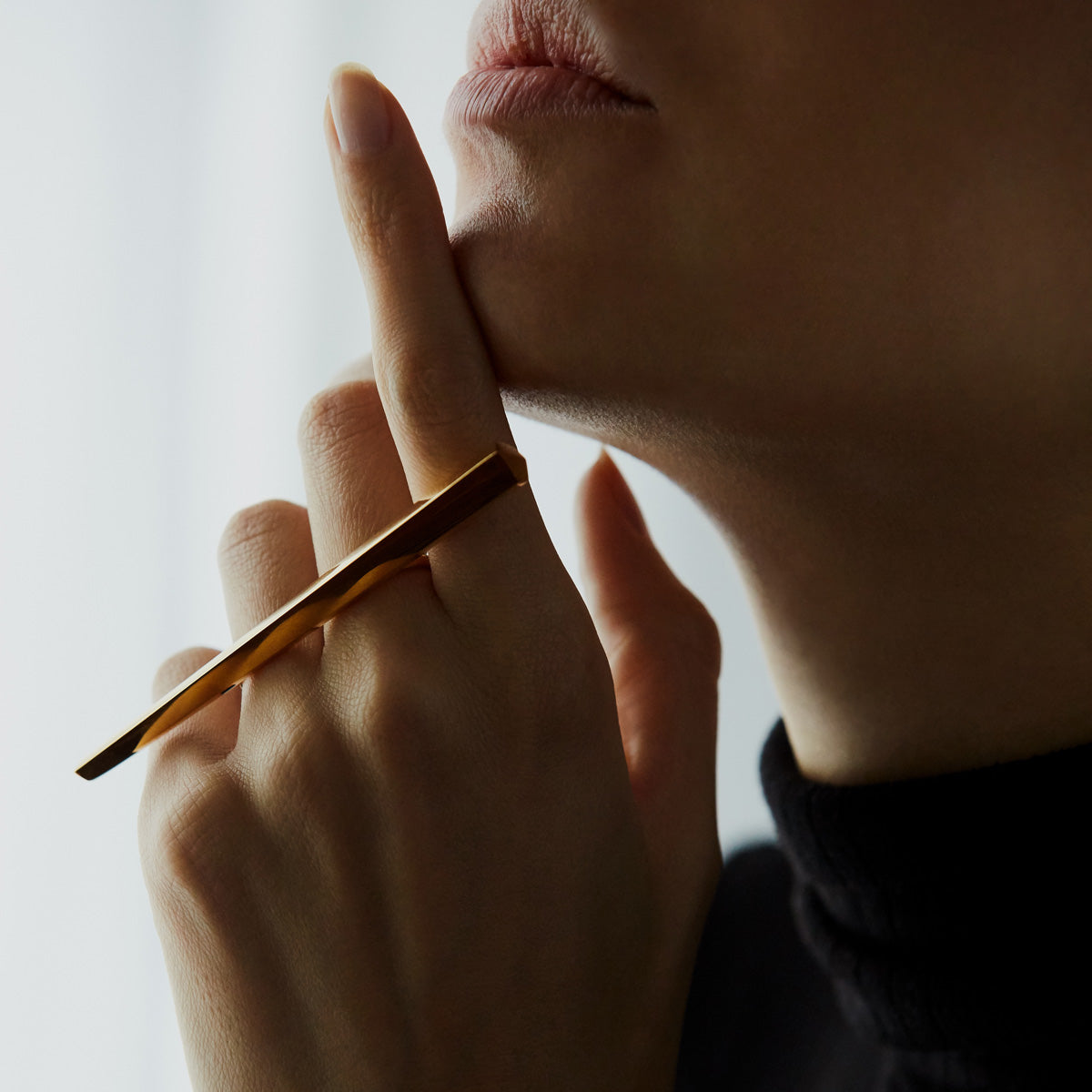 A fashion photography shot of statement ring and best seller GRAND PUNCH in its yellow gold version, by Canadian jewelry designer Bena Jewelry. We see the long slick statement jewel on a model hand. This ring is a thick chunk of gold that will keep it’s value.