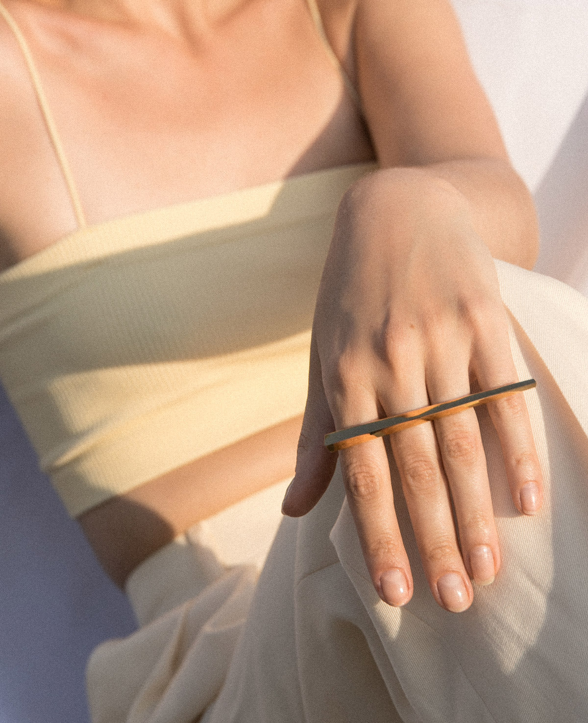 A close-up view of the GRAND PUNCH ring by Montreal jewelry designer Bena Jewelry, here worn by a casual young woman. This double finger ring in solid gold empowers. It’s a jewel of strength, style, courage and ambition.