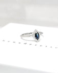 Side view of bena jewelry marquise shape blue sapphire with small white diamonds engagement ring custom made color gemstone montreal specialist bridal edgy jewelry design