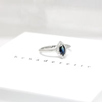 Side view of bena jewelry marquise shape blue sapphire with small white diamonds engagement ring custom made color gemstone montreal specialist bridal edgy jewelry design