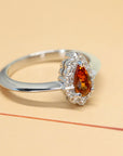 side view of white gold garnet and diamond engagement ring orange vivid spessartite garnet ring montreal bena jewelry handmade in little italy jeweler pear shape orange gemstone diamond ring color gems specialist montreal handmade fine jewelry