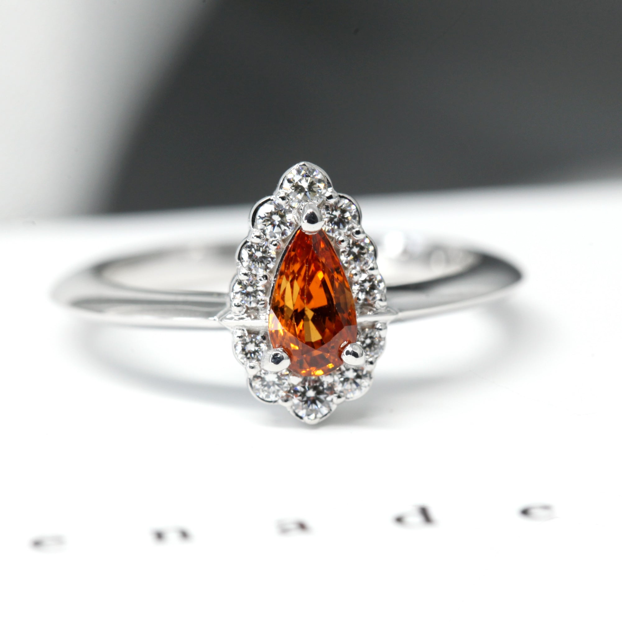 front view of orange garnet spessartite gemstone diamond halo ring white gold bena jewelry color gemstone custom made fine jewelry orange pear shape diamond montreal made in canada fine jewelry color gemstone bridal jewelry design