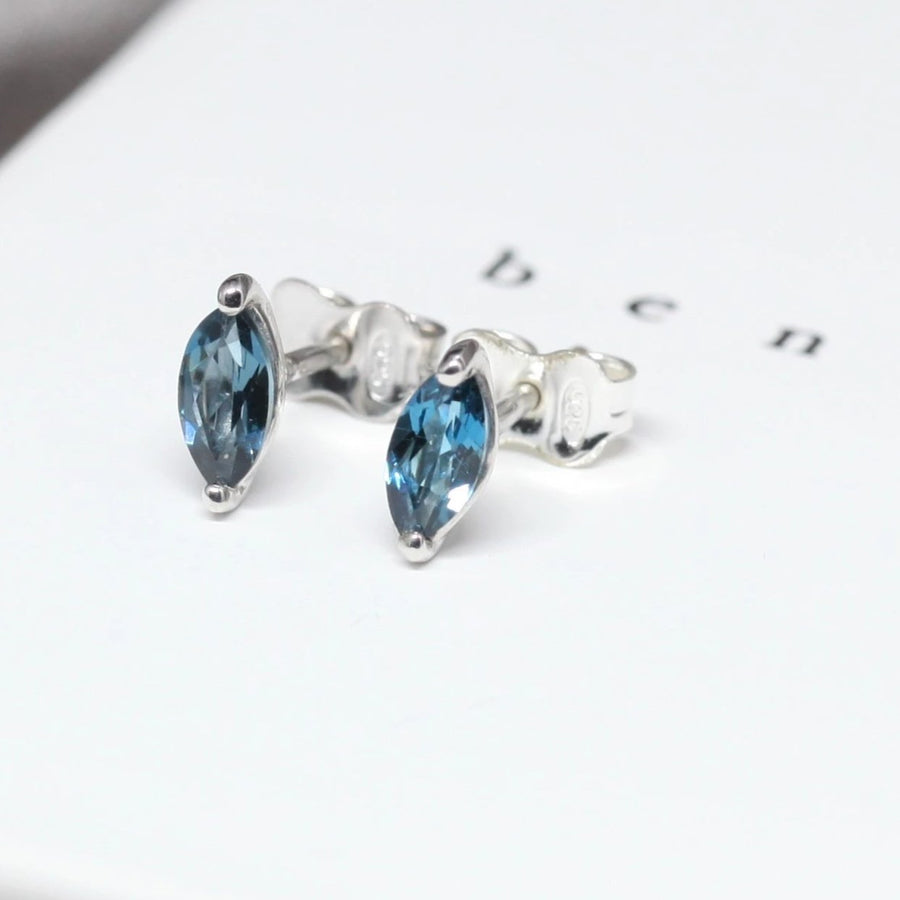 Side view of bena jewelry london blue topaz marquise shape small earrings custom color gemstone stud specialist silver earrings bena jewelry montreal fine jewelry designer