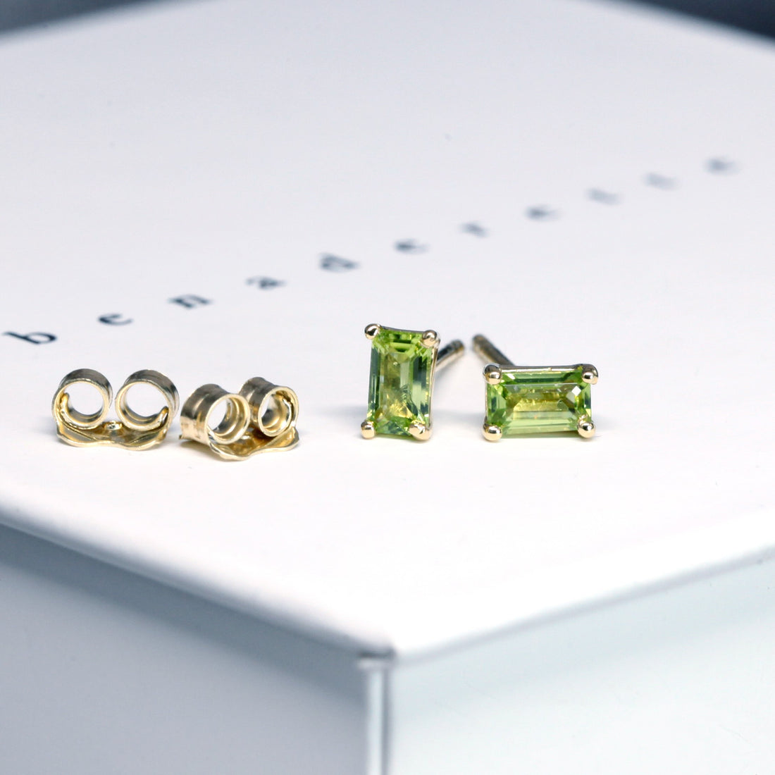 front view of bena jewelry peridot stud earrings custom made peridot jewelry montreal baguette shape gems earrings small green studs bena jewelry montreal handamde jewelry little italy jewelry studio
