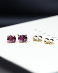 front view of rhodolite garnet oval gemstone gold stud earrings purple pink natural gemstone custom made gold earrings bena jewelry montreal yellow gold purple gemstone studs