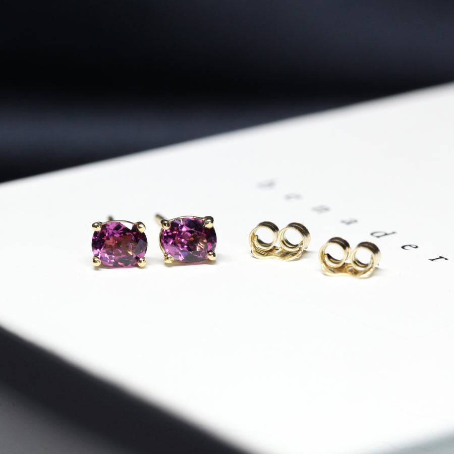 front view of rhodolite garnet oval gemstone gold stud earrings purple pink natural gemstone custom made gold earrings bena jewelry montreal yellow gold purple gemstone studs