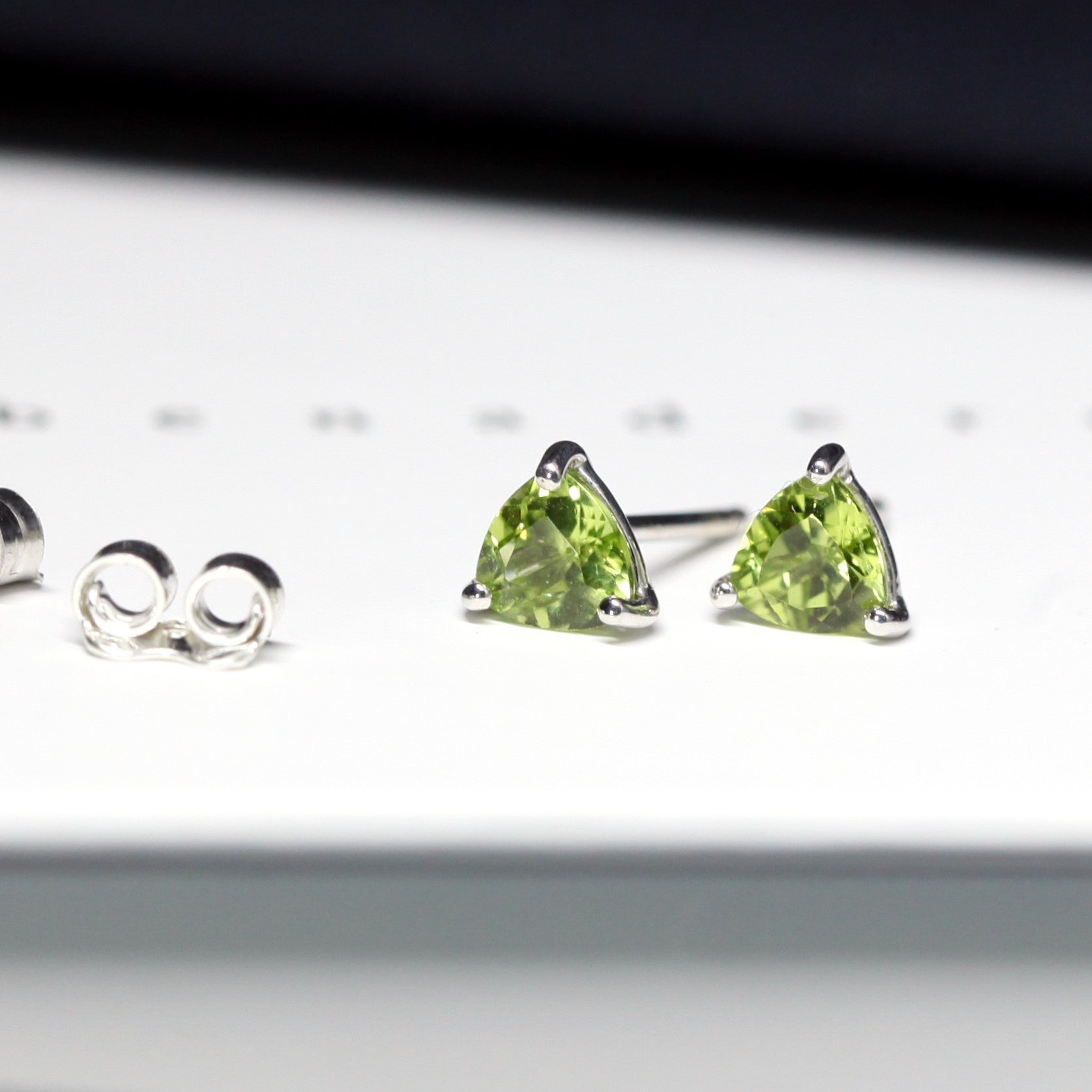 side view of bena jewelry gemstone stud earrings trillion shape peridot custom made gemstone jewelry bridal earrings bena jewelry montreal gemstone jewelry manufacture montreal color gemstone jewelry specialist small green gems earrings