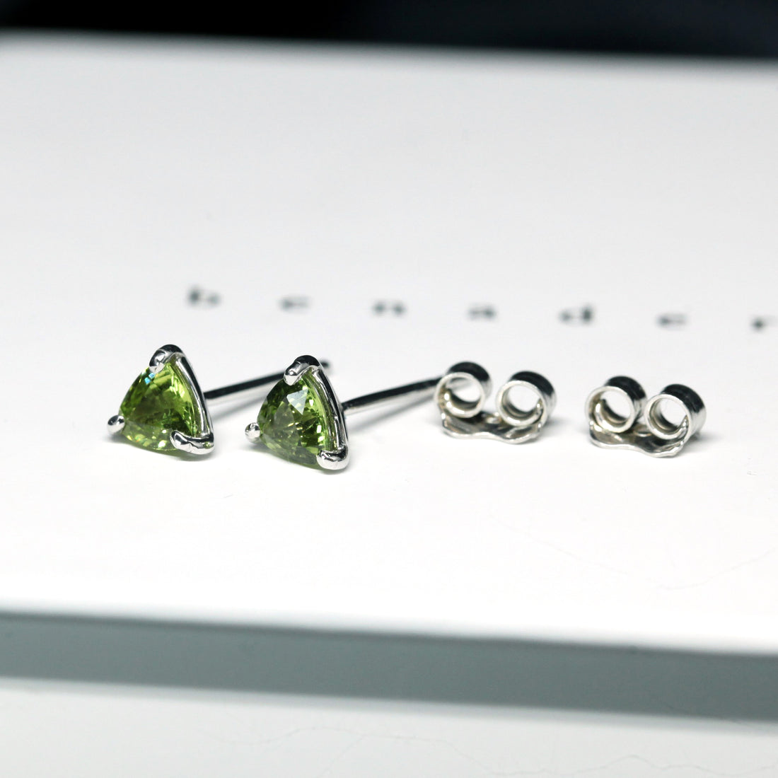 Side view of edgy small Bena Jewelry green sapphire small trilloin shape gemstone studs earrings custom made color gems bridal and everyday minimalist bold unisexe jewelry ethical custom made jewelry design montreal little italy jeweler natural gemstone stud earrings