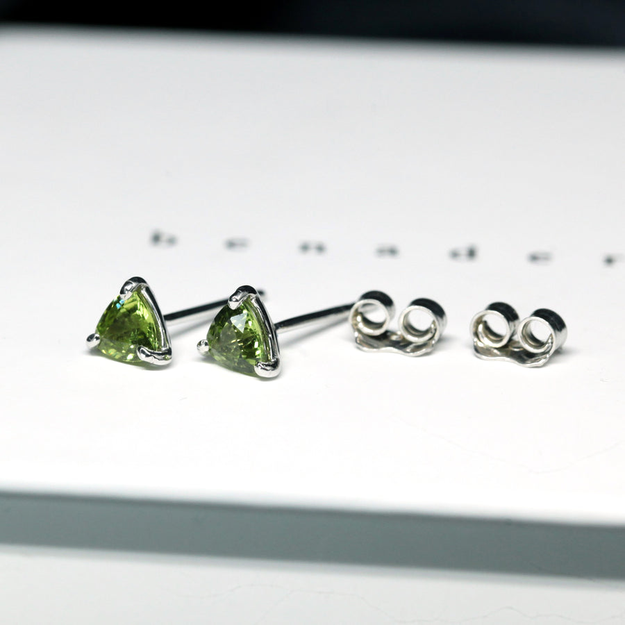 Side view of edgy small Bena Jewelry green sapphire small trilloin shape gemstone studs earrings custom made color gems bridal and everyday minimalist bold unisexe jewelry ethical custom made jewelry design montreal little italy jeweler natural gemstone stud earrings