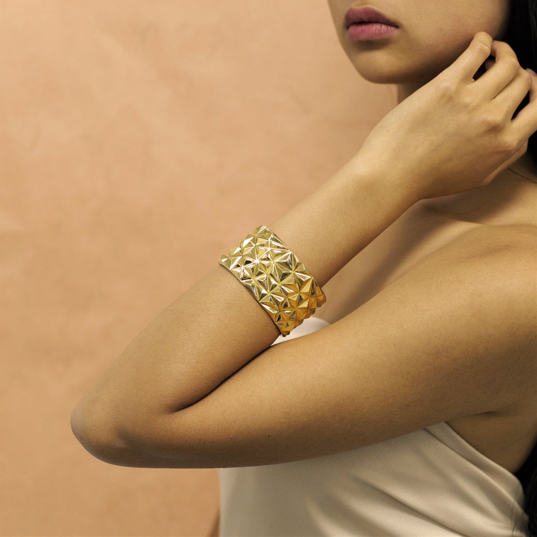 Girl wearing statement gold plated bracelet chiseled collection by bena jewelry montreal custom fine jewelry designer montreal made in canada