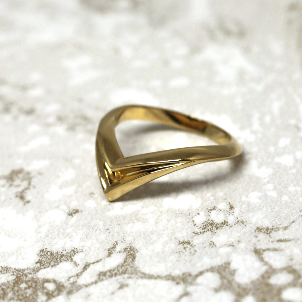 Unique yellow gold statement ring with angular curves, Adorn Ring by Bena Jewelry, displayed on a black matte background, modern edgy jewelry crafted in Montreal.
