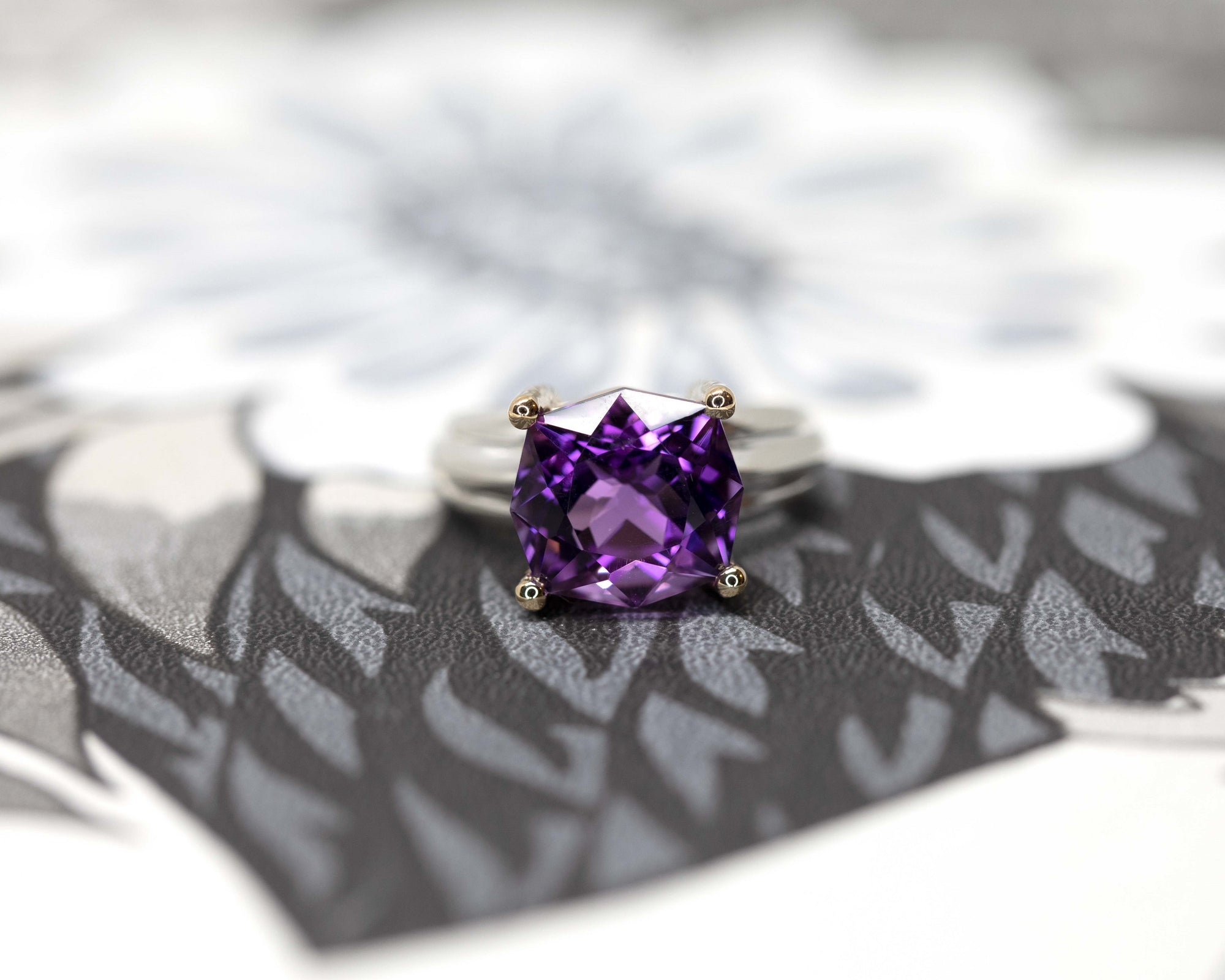 Close-up on gray background: Captures the intricate facets of the amethyst and the polished finish of the ring’s silver-gold combination. A masterpiece by Bena Jewelry, made in Montreal, Canada.
