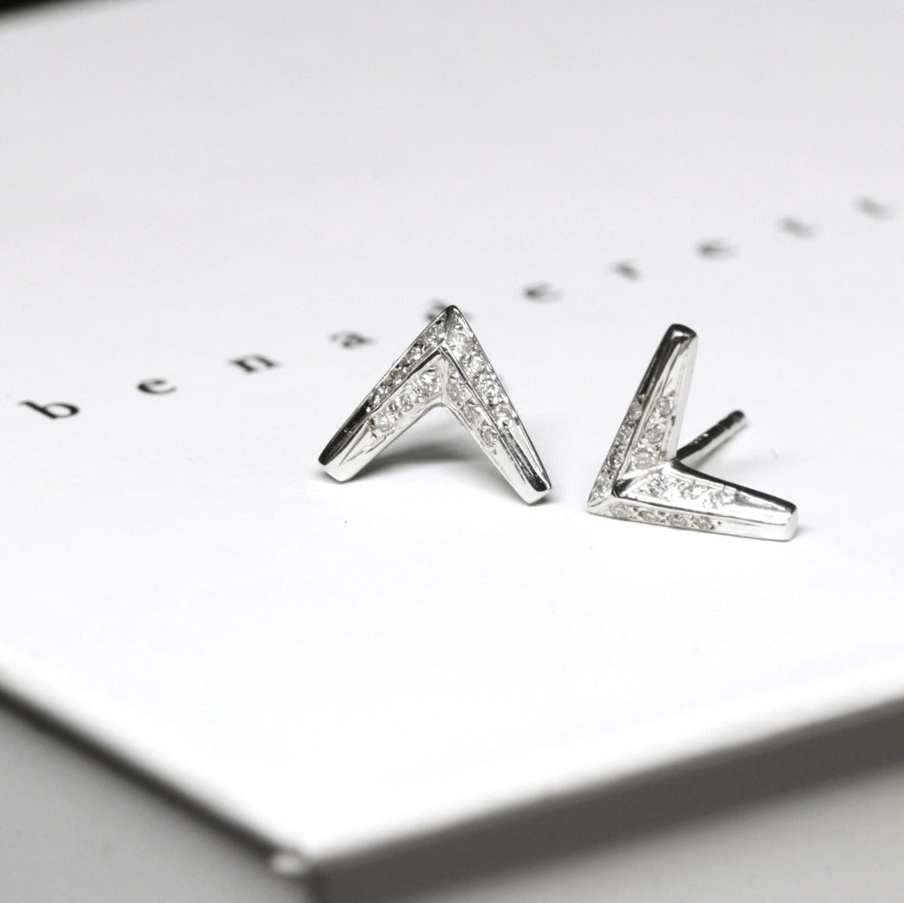 Close-up of Diamond Arrow Studs by Bena Jewelry, focusing on the details of the diamonds and the sharp, minimalistic arrow shape.