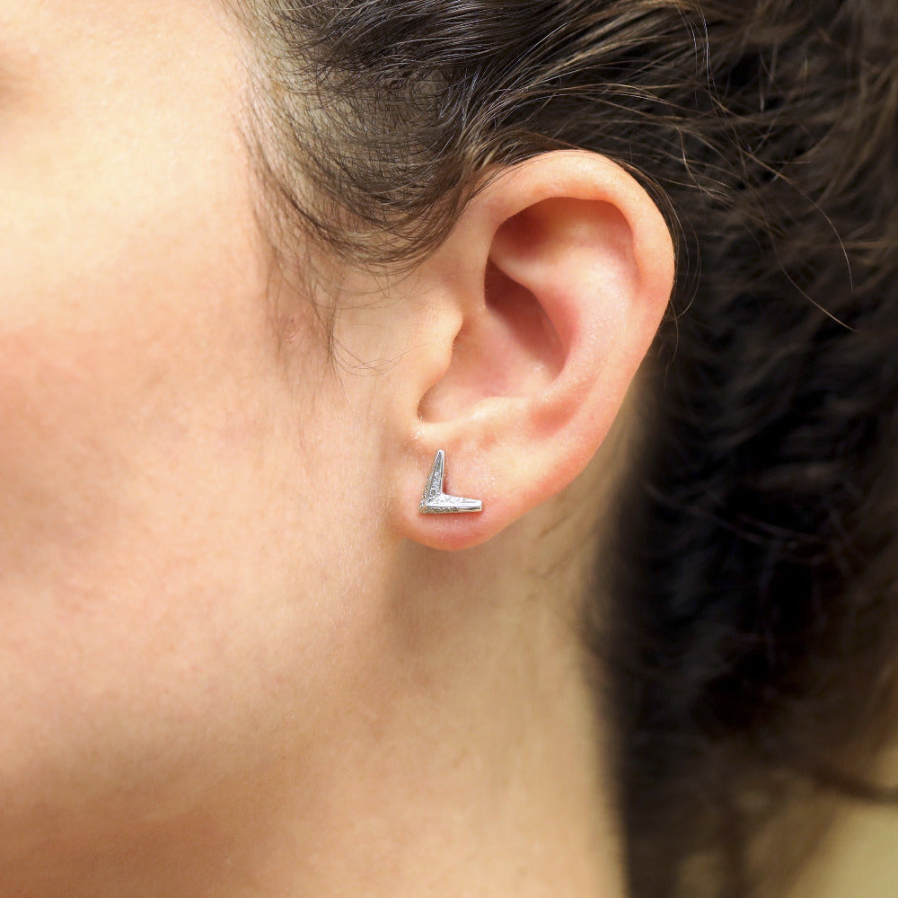 Close-up shot of the earrings worn, highlighting the sparkle of the diamonds and their subtle sophistication. The Arrow Studs Earrings are made in Canada by the designer Bena Jewelry.