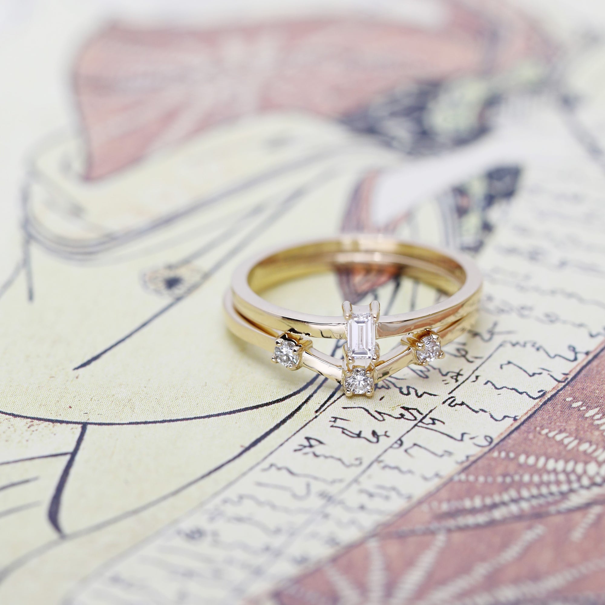 front view of set of gold ring with diamond custom made in montreal wedding bands on multi color background