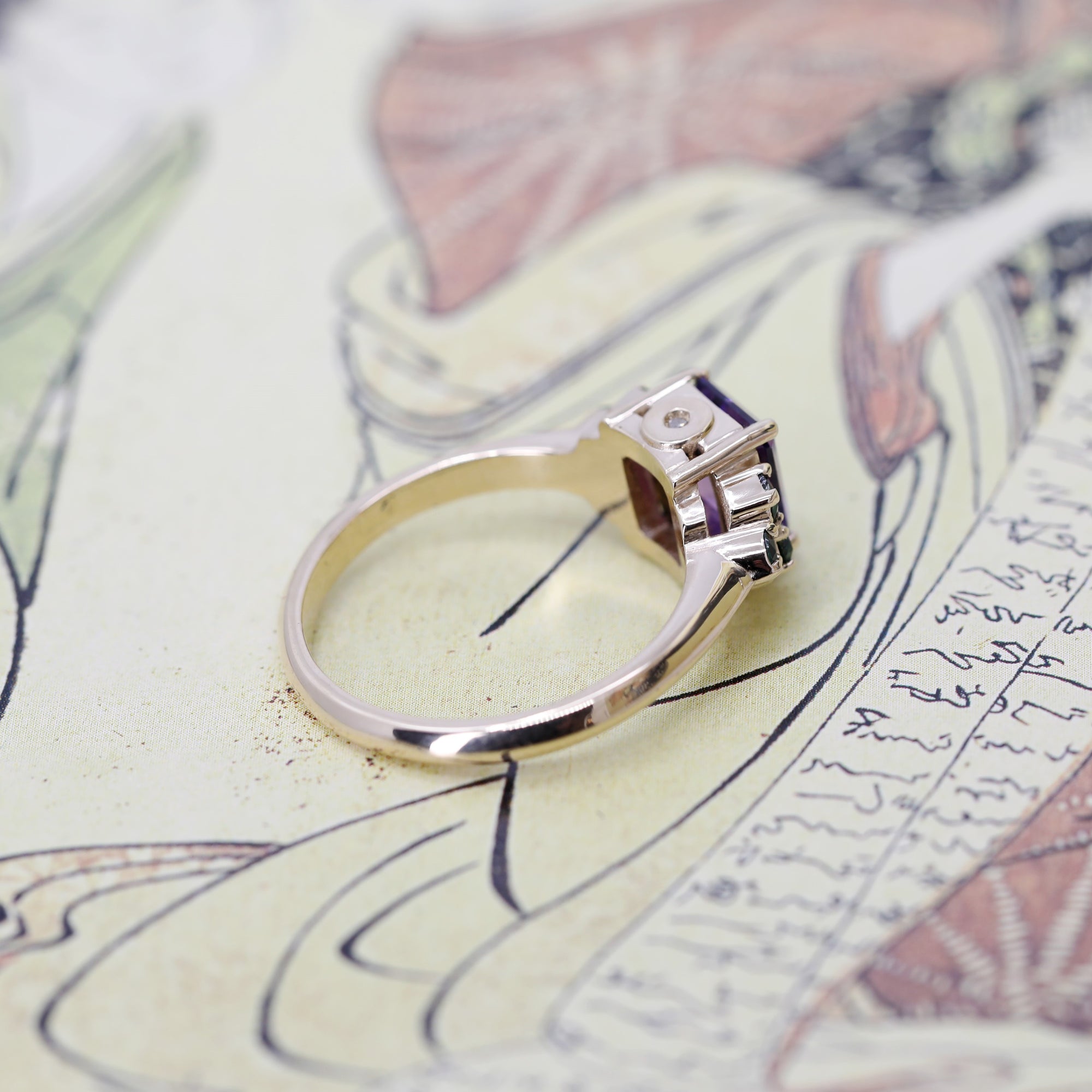 Close-up: Focus on the amethyst’s brilliance and the contrasting silver and gold elements on the hand.