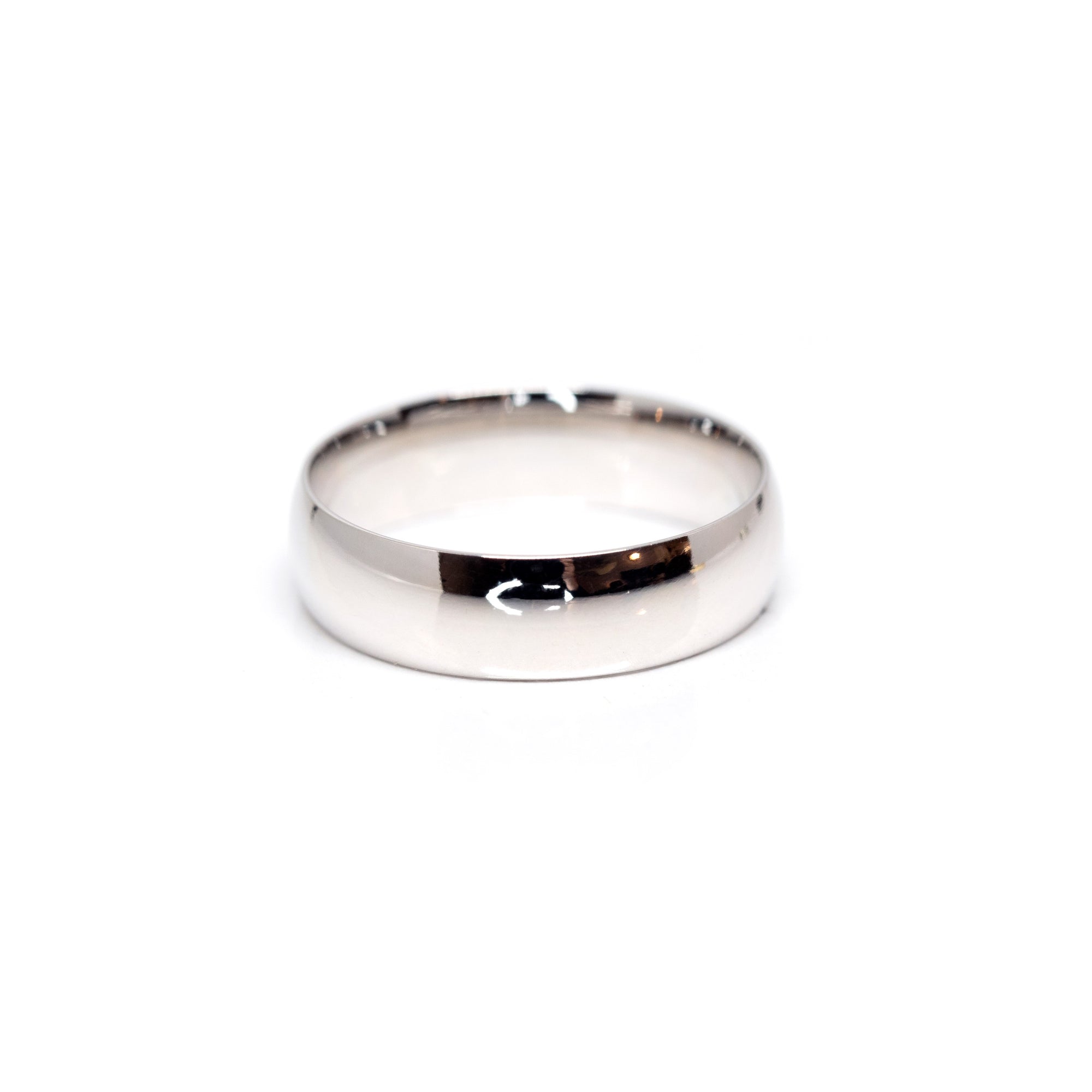 Minimalist white gold domed wedding band, crafted by Bena Jewelry in Montreal, offering a sophisticated and timeless look for modern weddings.