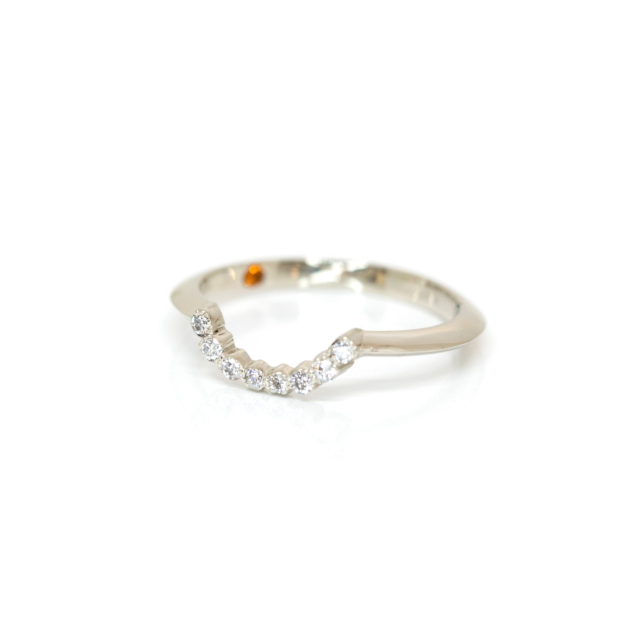Sleek white gold diamond ring with a modern curved style, showcasing a delicate pavé of round diamonds. Designed and made by Bena Jewelry in Montreal, perfect for stacking or pairing with an engagement ring.