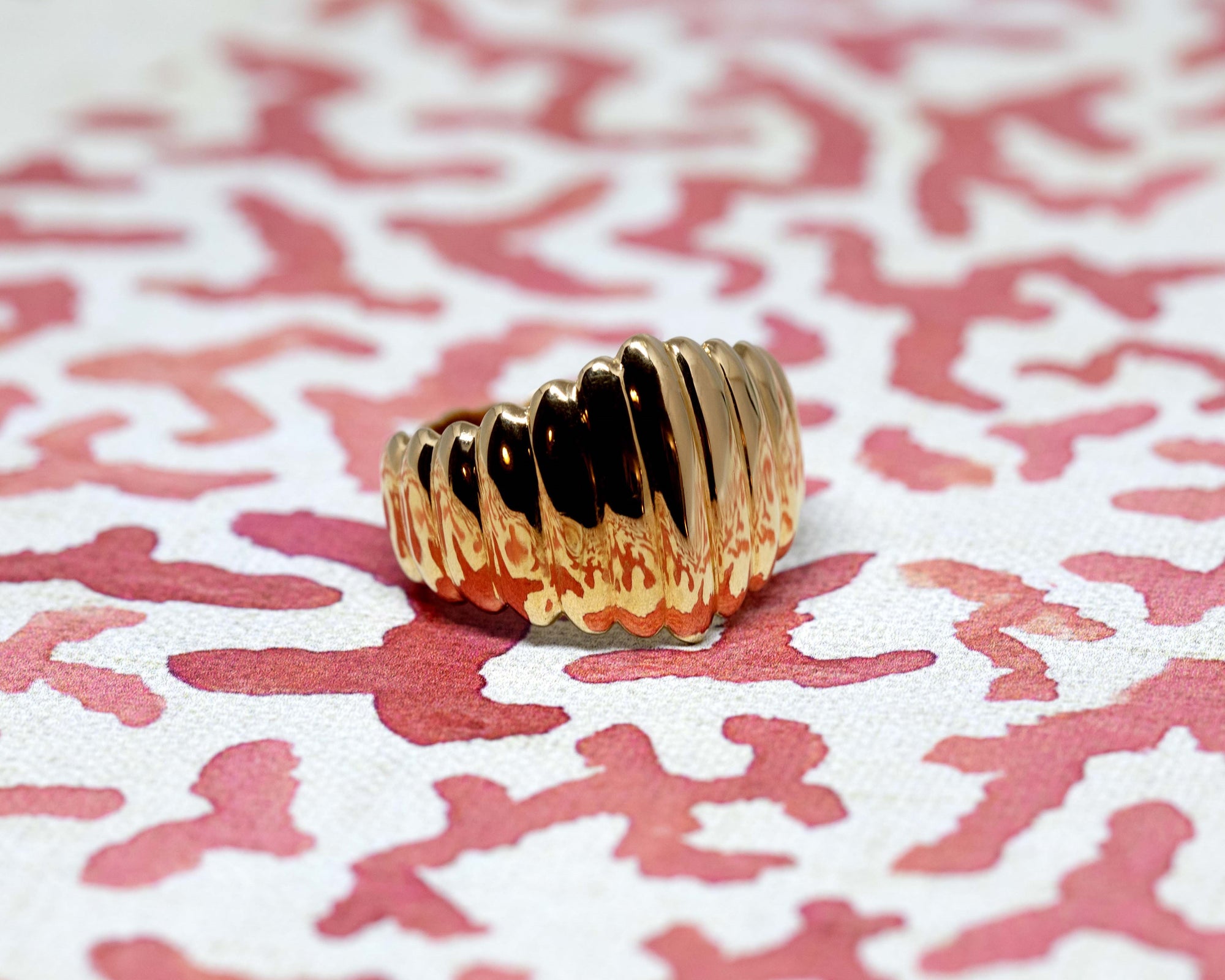  Angled shot of Pigalle Ring in Yellow Gold – A striking gold ring featuring a domed silhouette and a unique faceted pattern.