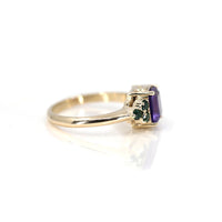 side view  of yellow gold ring with round small emerald natural gemstone and amethsyt square shape central stone cusotm made in montreal by bena jewelry engagement designer on white background