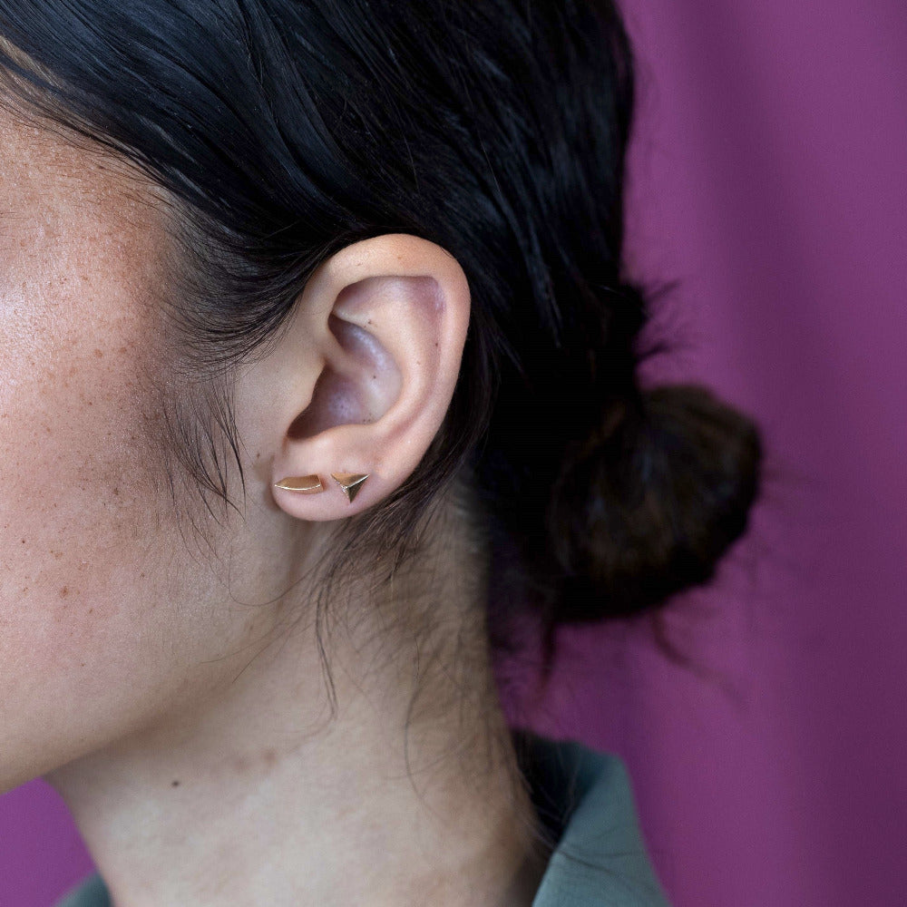 Bena Jewelry presents Delta Diamond Studs earrings. Side view highlighting the earrings’ thickness, yellow gold material, and the detailed craftsmanship of the diamonds.