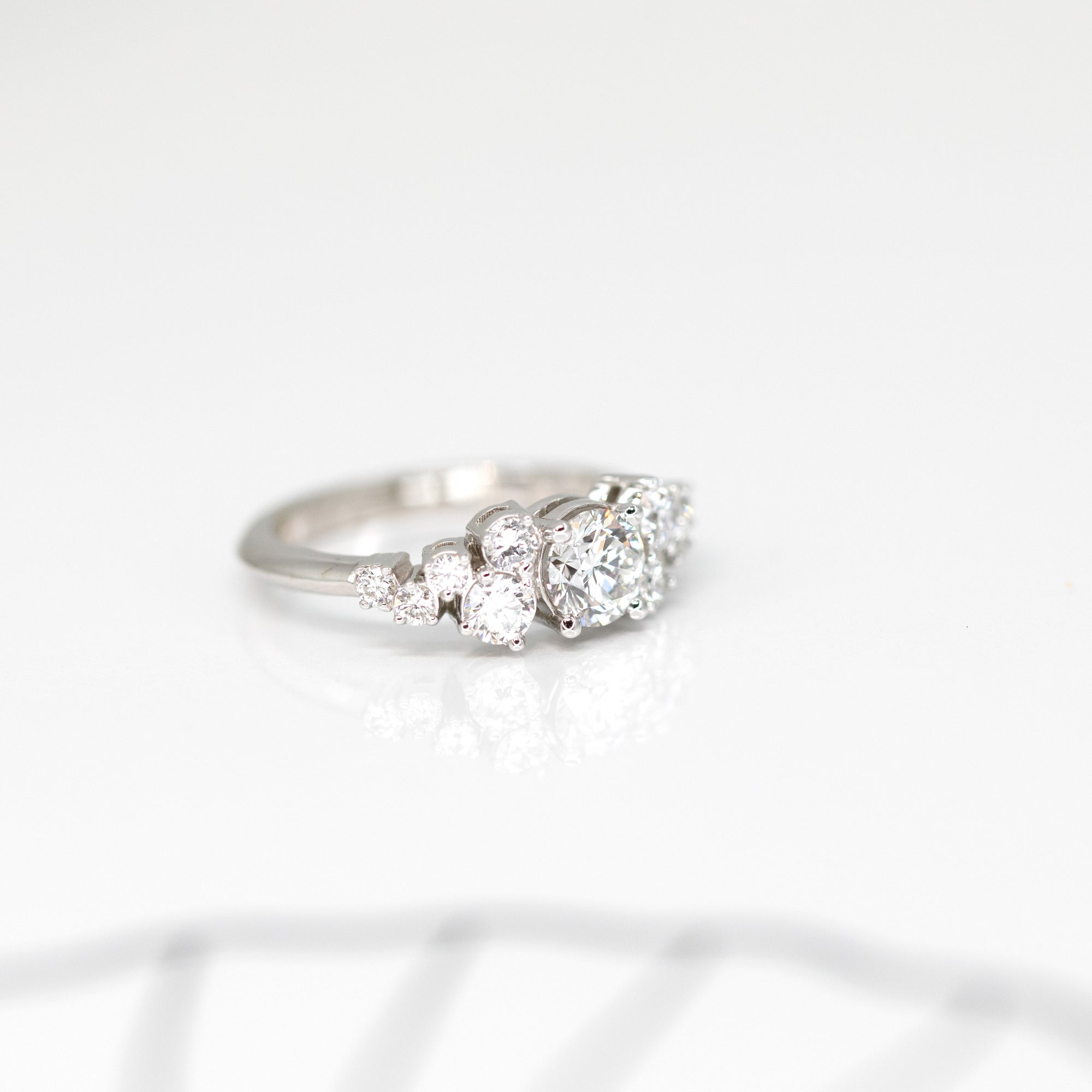 side view of custom made diamond engagement ring made by artisan bena jewelry designer for the jeweler ruby mardi in montreal on a white background