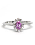 Diamond Halo Pink Sapphire Ring in white gold by Bena Jewelry featuring a pink oval sapphire and diamond halo, photographed on a white background, custom-made in Montreal.