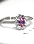 White gold engagement ring by Bena Jewelry featuring an oval pink sapphire and a diamond halo, custom-made in Montreal with natural gemstones.