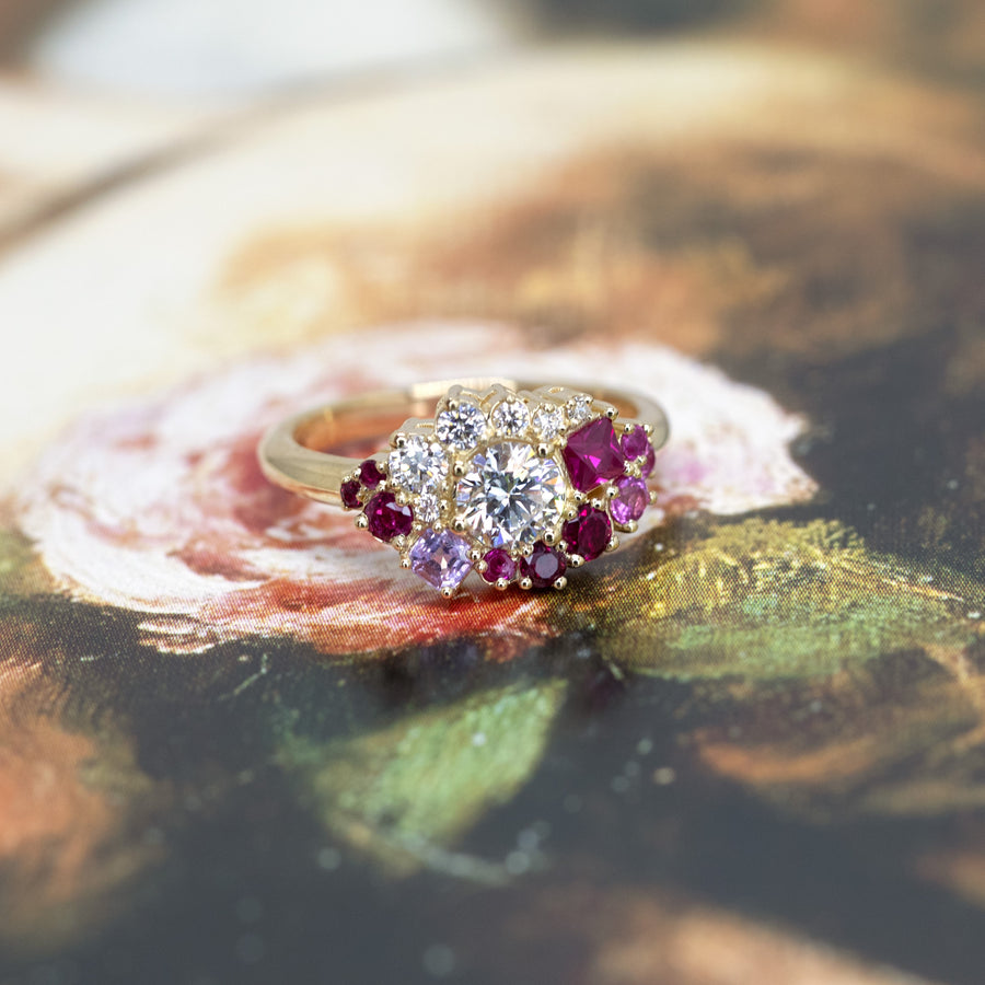 top view of round diamond lab grown ruby and pink sapphire custom made bespoke yellow gold bridal ring montreal on a multi color background