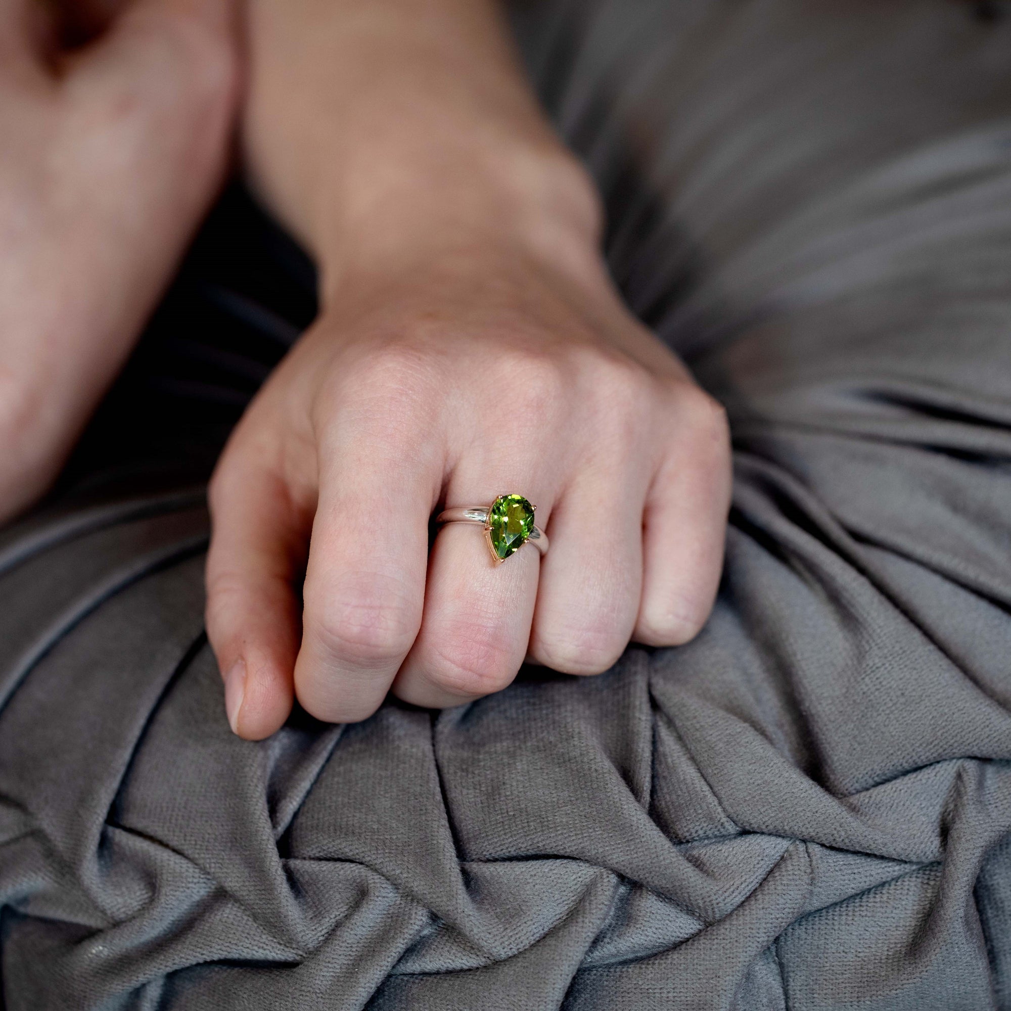 Lifestyle shot of peridot ring worn on fingers – The deep green gemstone stands out as a luxurious, powerful statement piece, designed by Bena Jewelry.
