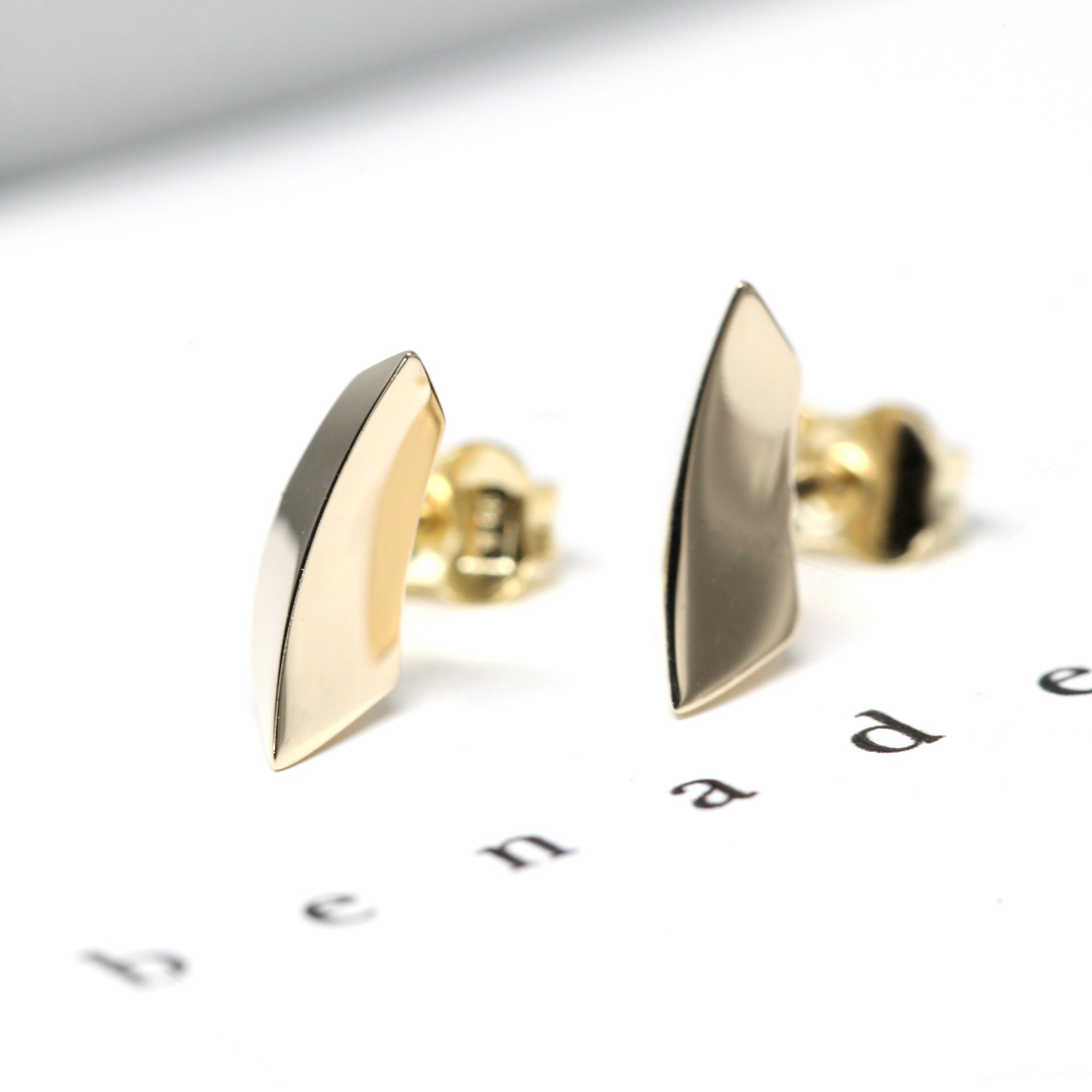 Vibrant display of the Brace Studs in yellow gold, a modern creation by an independent jewelry designer in Montreal.